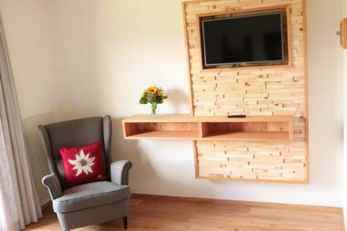 a room with a chair and a television on a wall at Haus Christophorus in Mariapfarr