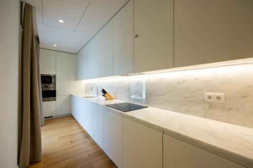 a kitchen with white cabinets and a counter top at Marinha Prime in Cascais