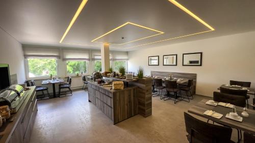 a room with a restaurant with tables and chairs at Hotel Schmidt garni in Essen