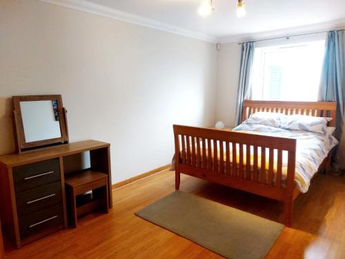a bedroom with a bed and a mirror and a dresser at Seafront Holiday Home in Southend-on-Sea