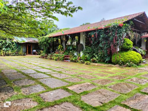 a house with a garden in front of it at Edgestay in Mudigere