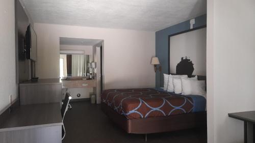 Habitación de hotel con cama y espejo grande en Super 8 Motel by Wyndham near Fort Lauderdale Arpt en Dania Beach