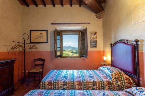 a bedroom with a bed and a window at Podere Cunina in Buonconvento