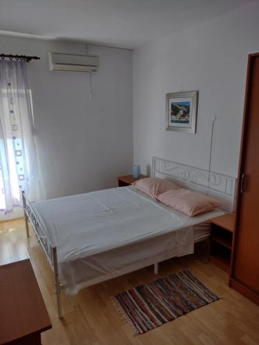 Habitación blanca con cama y ventana en Family Majčica - villa Malo Misto, en Klek