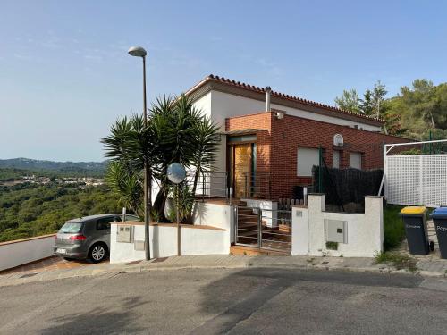 a house with a car parked in front of it at Villa for 2 families in Blanes