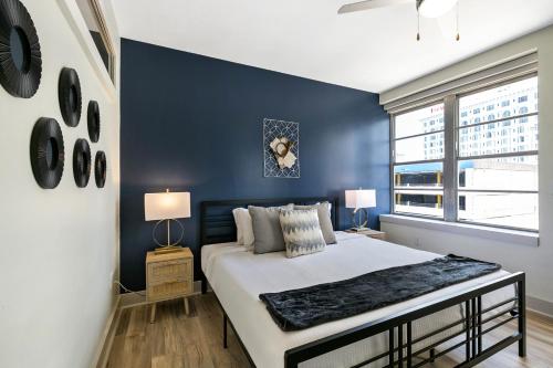 1 dormitorio con 1 cama grande y pared azul en California Building by Hosteeva, en Nueva Orleans