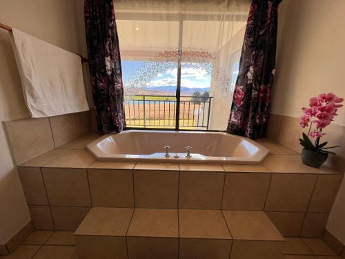 a bath tub in a bathroom with a window at House At The Stables in Himeville