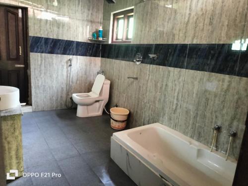 een badkamer met een bad, een toilet en een wastafel bij Edgestay in Mudigere