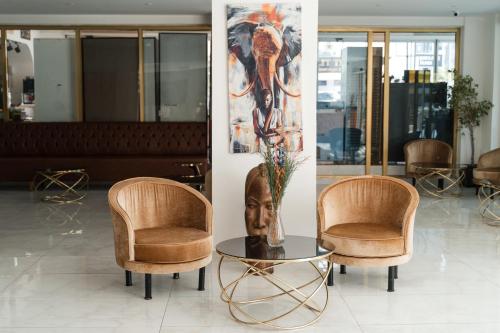 two chairs and a table with a vase in a room at Far Life Hotel in Antalya