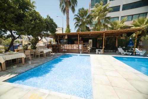 a swimming pool with a restaurant and a hotel at Far Life Hotel in Antalya