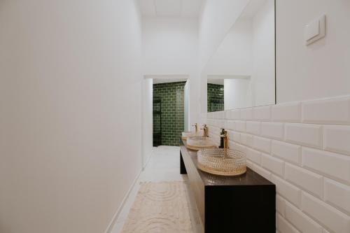 a bathroom with three sinks and white walls at Porto Hostel Cúpula in Porto