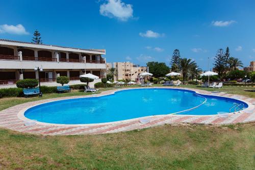 a large blue swimming pool in front of a building at Marina Hills Residence in El Alamein