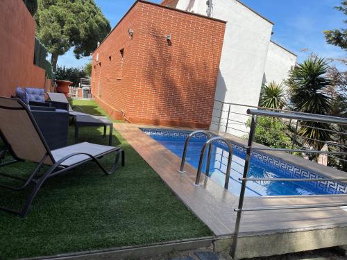una piscina en un patio con un banco y una silla en Villa for 2 families, en Blanes