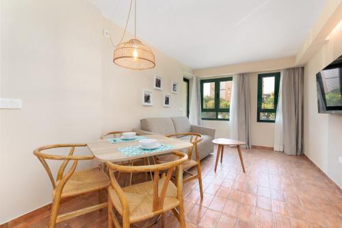 Una sala de estar con una mesa y sillas y un sofá. en Apartamentos Las Ciencias I, en Valencia