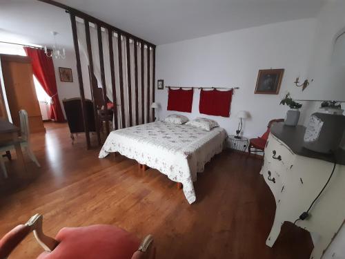 ein Schlafzimmer mit einem Bett in einem Zimmer mit Holzböden in der Unterkunft La maison de Maria in Saint-Beauzire