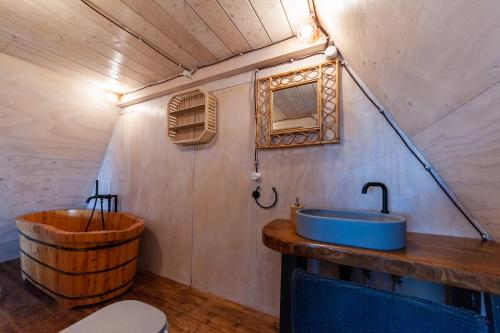 a bathroom with a sink and a wooden tub at AgriResort Spa Glamping Poggio Di Montedoro in Montefiascone