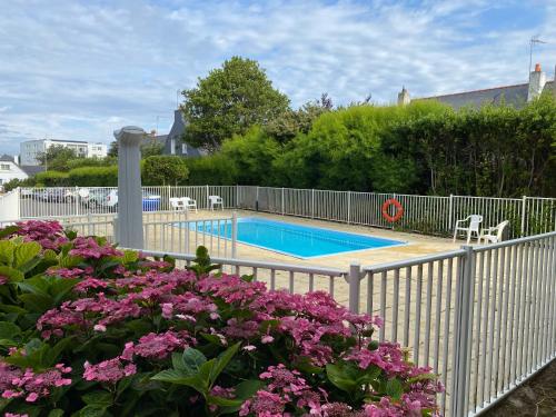 - une piscine avec des fleurs roses à côté d'une clôture dans l'établissement Centre-ville - Plage à pied - Calme - Parking, à Quiberon