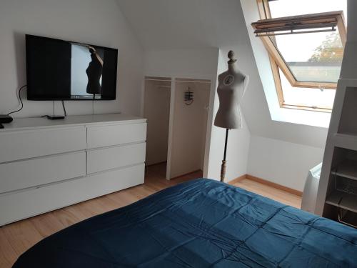- une chambre avec une télévision et une commode avec un lit dans l'établissement Maison entre terre et mer ***, à Concarneau