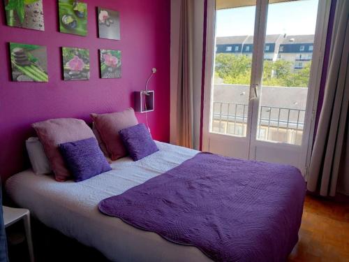 une chambre violette avec un lit et une fenêtre dans l'établissement Vue sur la Basilique 'St 'Rémi, à Reims