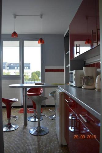 une cuisine avec une table et des tabourets de bar dans l'établissement Vue sur la Basilique 'St 'Rémi, à Reims