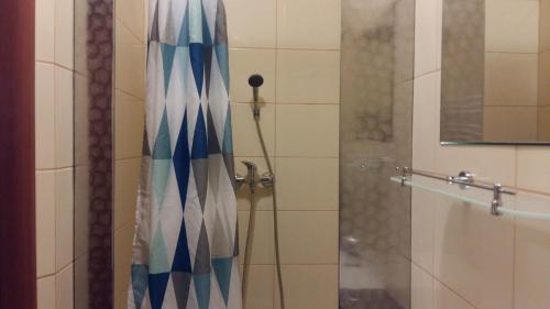 a shower with a blue and white shower curtain at Noclegi Zwycięstwa 34A in Międzyzdroje