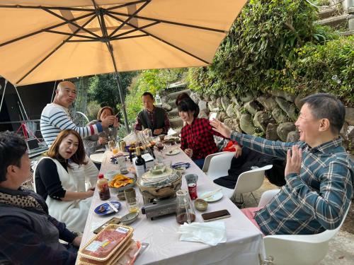 XXUFO في أتامي: مجموعة من الناس يجلسون حول طاولة مع مظلة