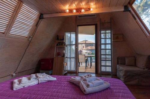 a bedroom with a purple bed with towels on it at AgriResort Spa Glamping Poggio Di Montedoro in Montefiascone