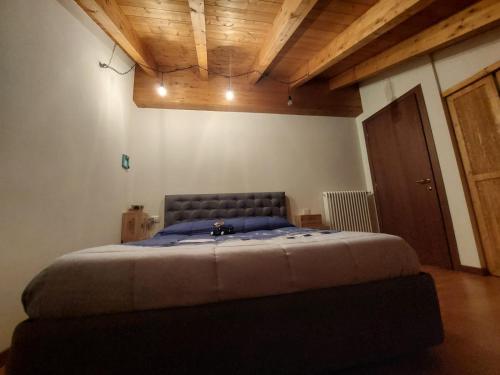a bedroom with a large bed in a room with wooden ceilings at Ai piedi della grigna in Pasturo