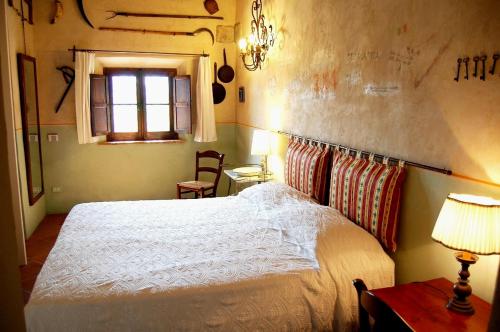 a bedroom with a white bed and a window at Podere Cunina in Buonconvento