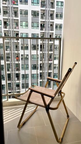 a wooden chair in front of a large window at The base Central Pattaya 903 by Numam in Pattaya Central