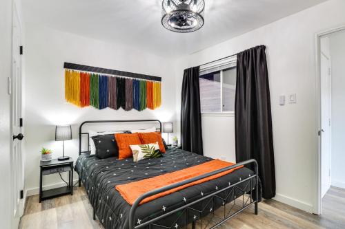 a bedroom with a black bed with orange pillows at Hip Austin Vacation Rental 3 Mi to Downtown in Austin