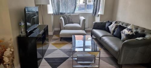 uma sala de estar com um sofá e uma mesa de centro em Westcliff - On -Sea em Southend-on-Sea