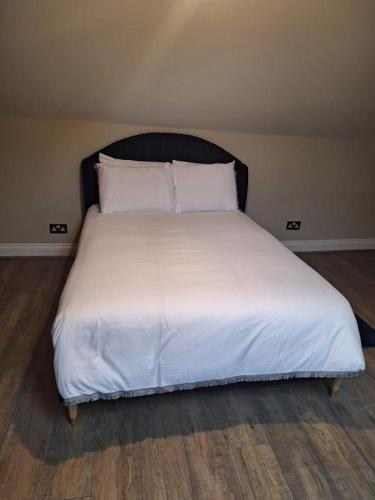 a bed with white sheets and pillows in a room at Westcliff - On -Sea in Southend-on-Sea