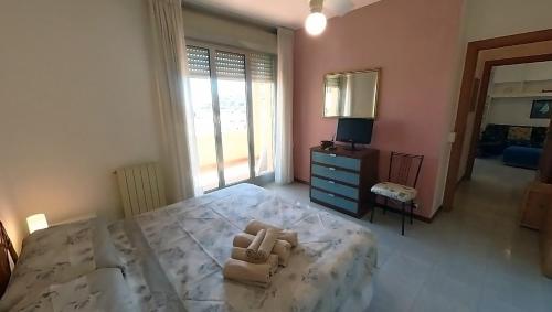 1 dormitorio con 1 cama, vestidor y TV en Casa Enry, en Spotorno