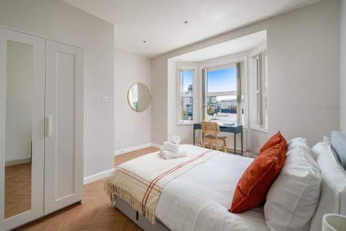 een witte slaapkamer met een groot bed en een raam bij Skyline Serviced Apartments - Julians Road in Stevenage