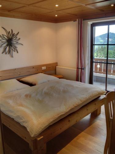 史岱伯斯的住宿－Chalet Edelweiss，一间带木床的卧室,位于带窗户的房间内