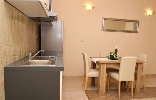 eine Küche mit einem Waschbecken und einem Tisch mit Stühlen in der Unterkunft Apartment Ančica in Split