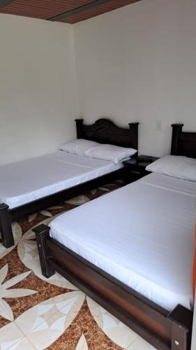 a group of three beds in a room at Cabañas Amalú in San Agustín