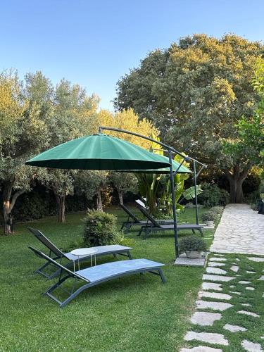 a green umbrella and some chairs and a table at Oasi di Campagna in Modica