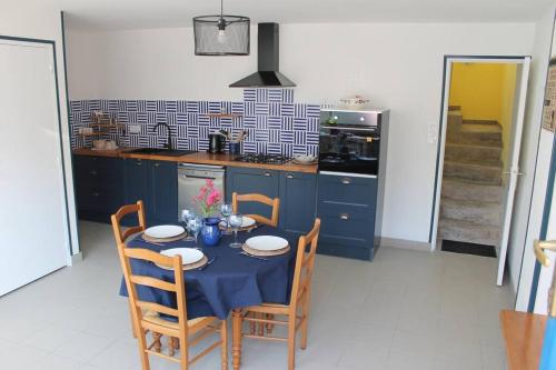 uma cozinha com uma mesa com uma toalha de mesa azul em Maison rénovée Atoué loc em Fresnay-sur-Sarthe