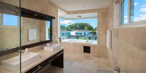 a large bathroom with two sinks and a large window at Your Home Away From Home in San Felipe de Puerto Plata