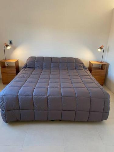 a large bed in a room with two night stands at Departamento a estrenar en los caminos del vino in Maipú
