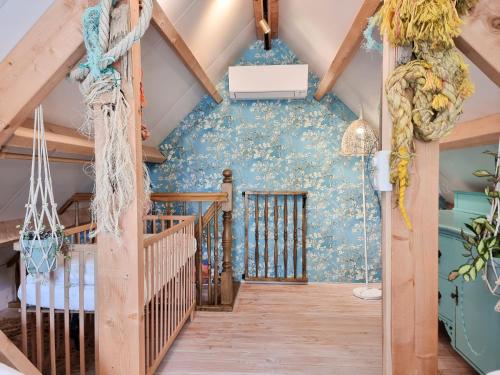 a staircase in a attic with a blue wall at Vakantiehuis Dishoek DI04 in Dishoek