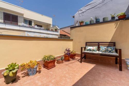 a patio with a bench and potted plants on a building at The Cyclops Retreat - Seaview in Aci Castello