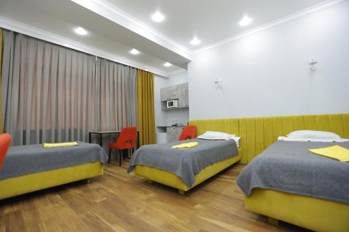 a hotel room with two beds and a table at Apart Hotel Bishkek in Bishkek