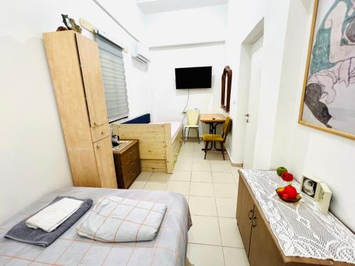 een kleine kamer met een bed en een bureau met een televisie bij Уютная Квартира 1,5 комнаты. in Haifa