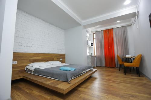 a bedroom with a bed and a dining room with a table at Apart Hotel Bishkek in Bishkek