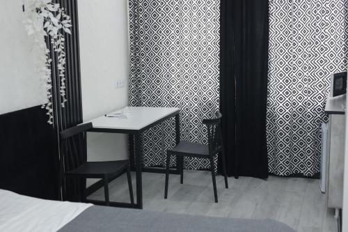 a room with a table and two chairs and a bed at Apart Hotel Bishkek in Bishkek