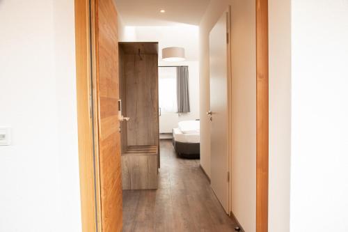 un couloir avec une porte menant à une chambre dans l'établissement Landgasthof Maier, à Vilsbiburg