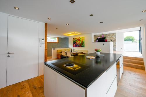 a kitchen with a black counter top and a living room at Alpin Chalet Arte in Söll